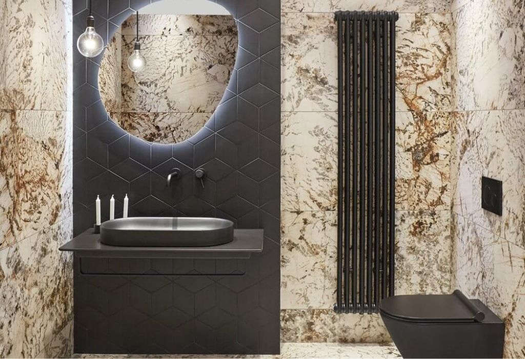 Bathroom with diamond-shaped tiles and stone. Finned radiator black, black fittings